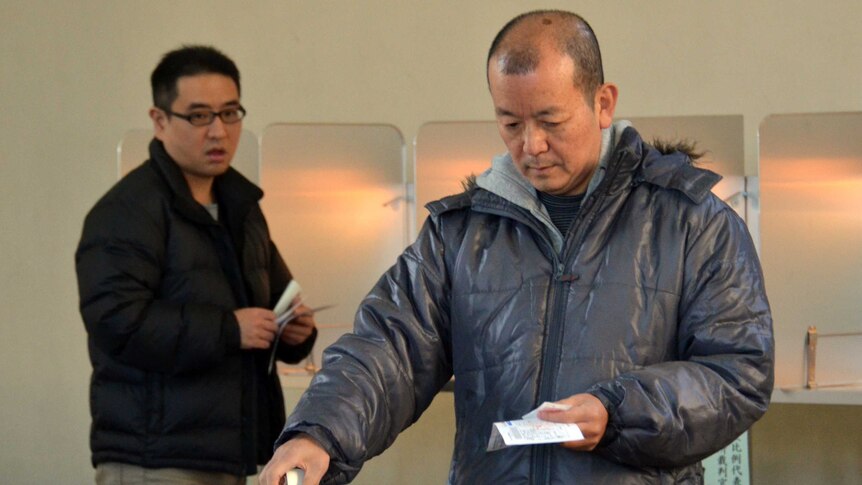 People cast their votes in Japan's general election at a polling station in Tokyo, December 16, 2012.