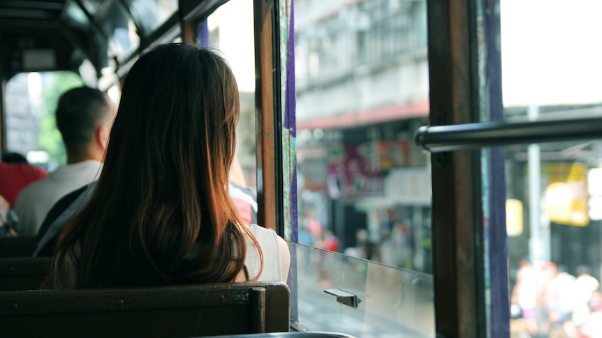 A photo of the backs of people's heads sitting on a bus.