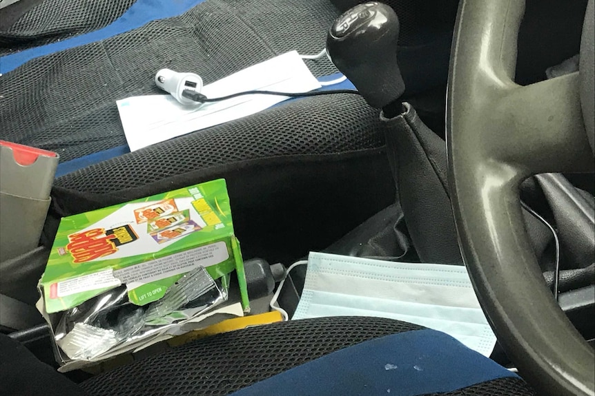 Face masks and a packet of Shapes biscuits on the front seats of a car