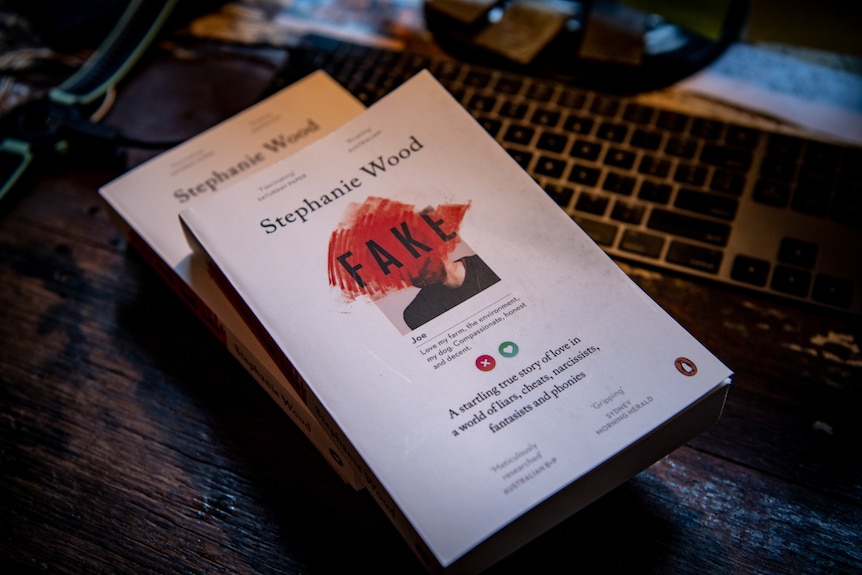 A stack of books with a white cover and red 'scribble' over a dating profile picture with the title 'Fake'