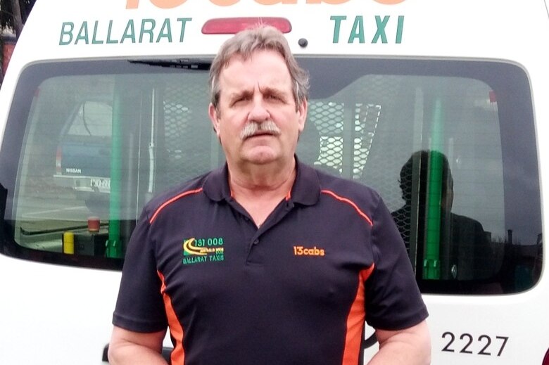 A man standing in front of a Ballarat taxi van.