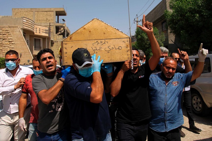 A group of men in Iraq carry a coffin while shouting