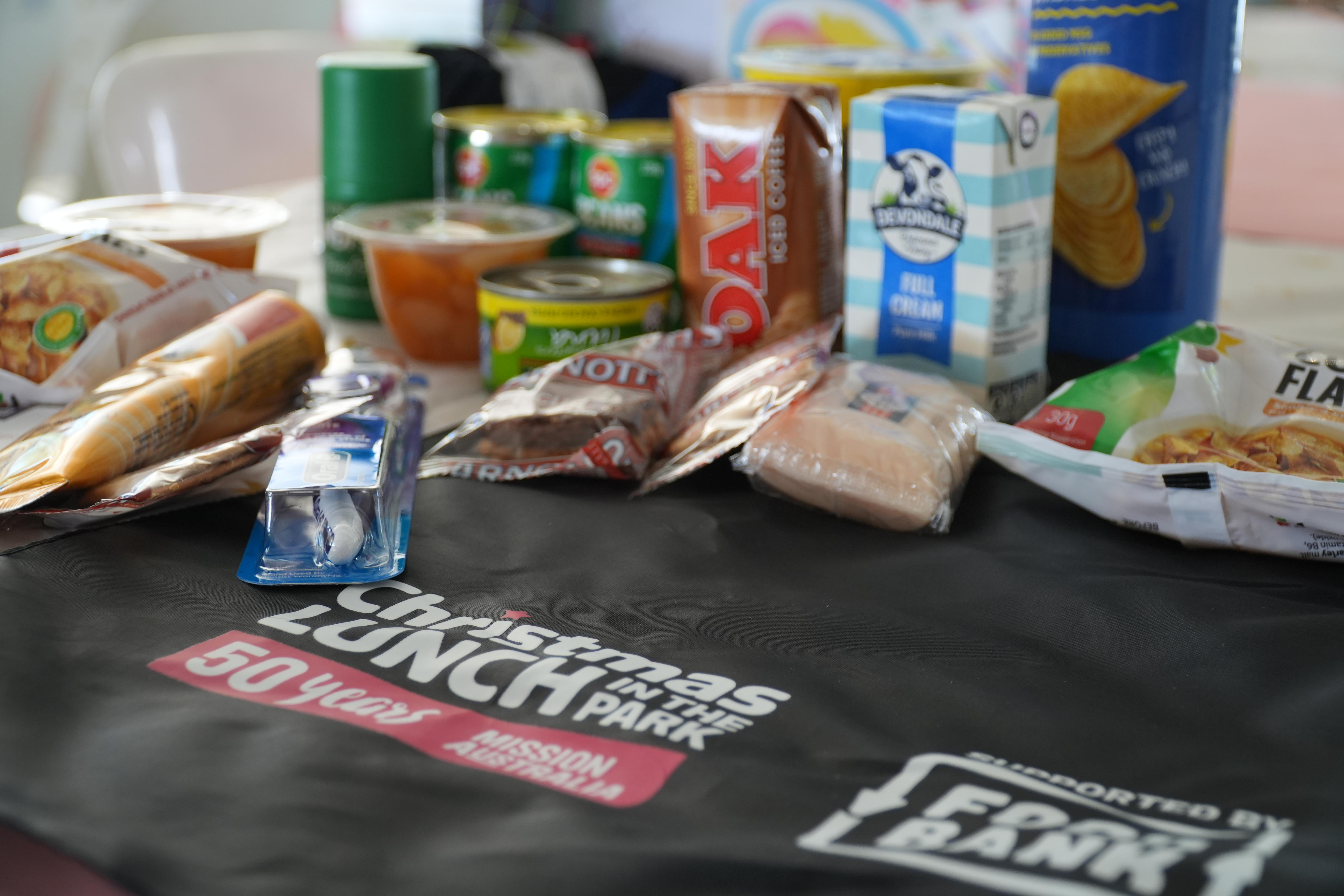 Itens essenciais da despensa alinhados em uma mochila com pacote de cuidados.