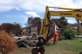 Machinery is used to clear debris from the 100th property to be cleaned after the Dunalley bushfire.