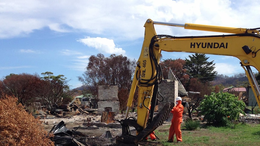 Machinery is used to clear debris from the 100th property to be cleaned after the Dunalley bushfire.