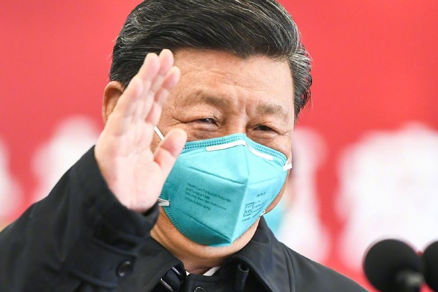 中国国家主席习近平戴着医用口罩，在一场看似新闻发布会上挥手致意