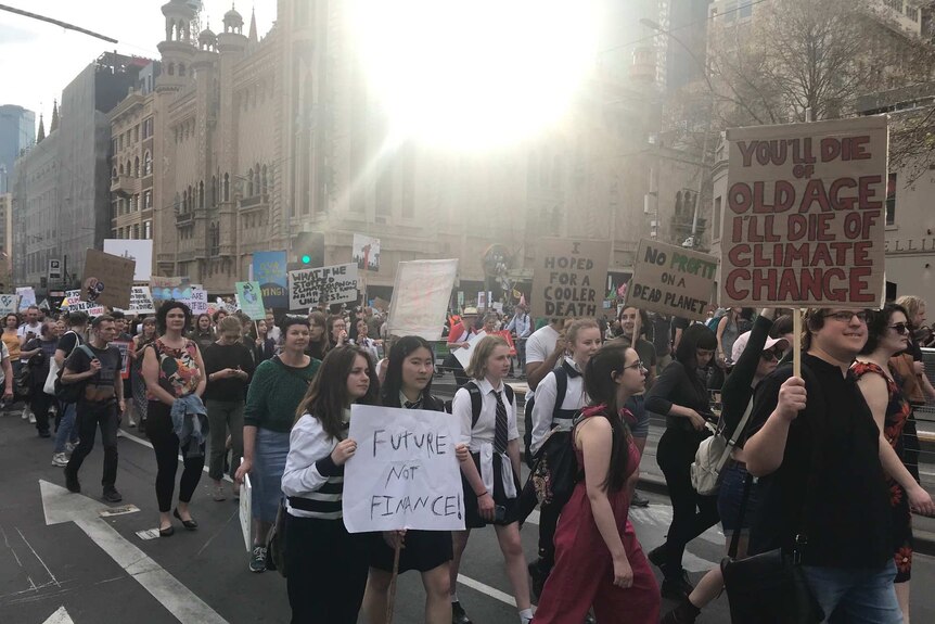 A group of students rally in Melbourne under a glaring sun.