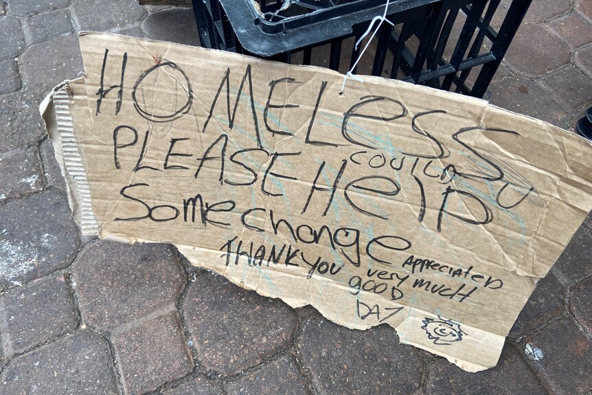 A cardboard sign asking people for spare change.