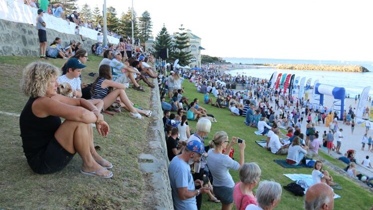 People line the grass areas at Cottesloe beach to watch the start of the Rottnest channel swim.