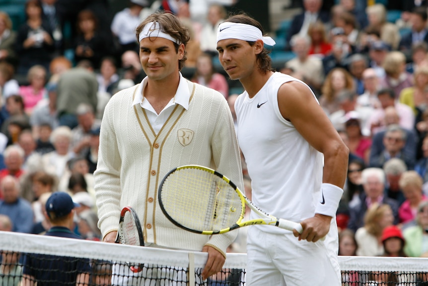 Roger Federer, in a cardigan, and Rafael Nadal, in a sleeveless tank top, pose for a photo at the net before the Wimbledon final