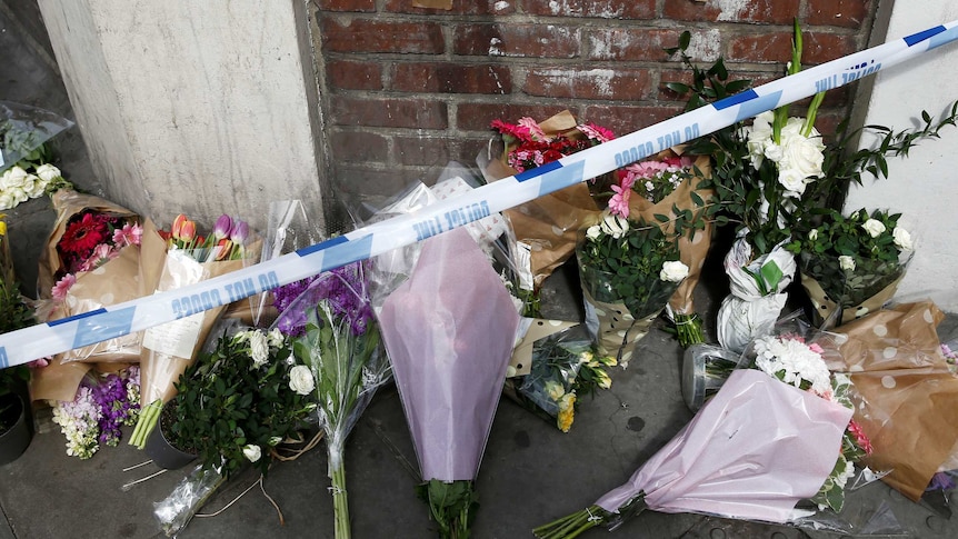 Flowers and messages lie behind police cordon tape near Borough Market after an attack left seven people dead in London.