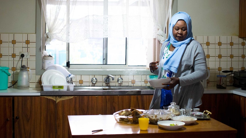 Kadiga prepares dinner in the kitchen.