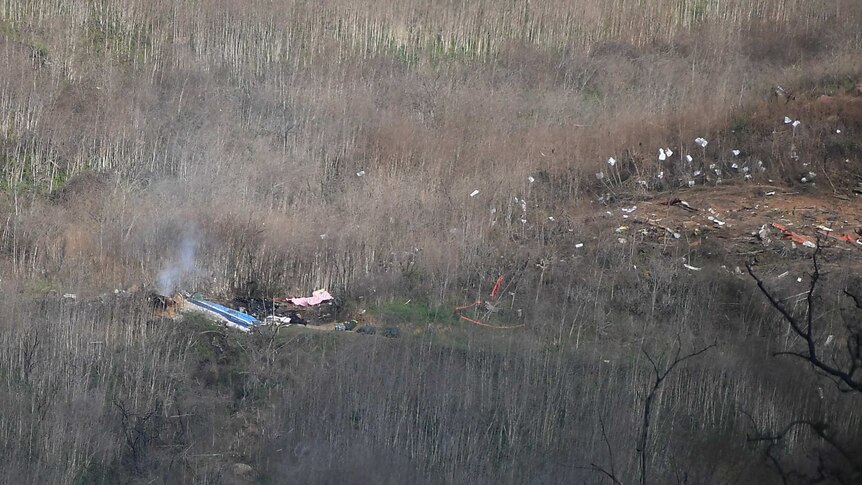 Debris and smoke after the helicopter crash that killed nine people