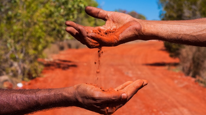 Hands with red soil