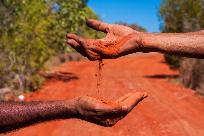 Hands with red soil