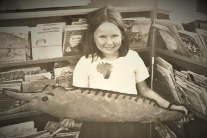 A young Debby Daniels poses with a cut-out fish drawing.