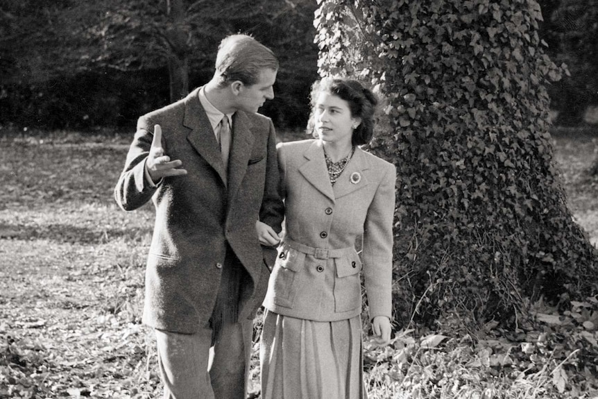 A young Princess Elizabeth and The Duke of Edinburgh walk together.