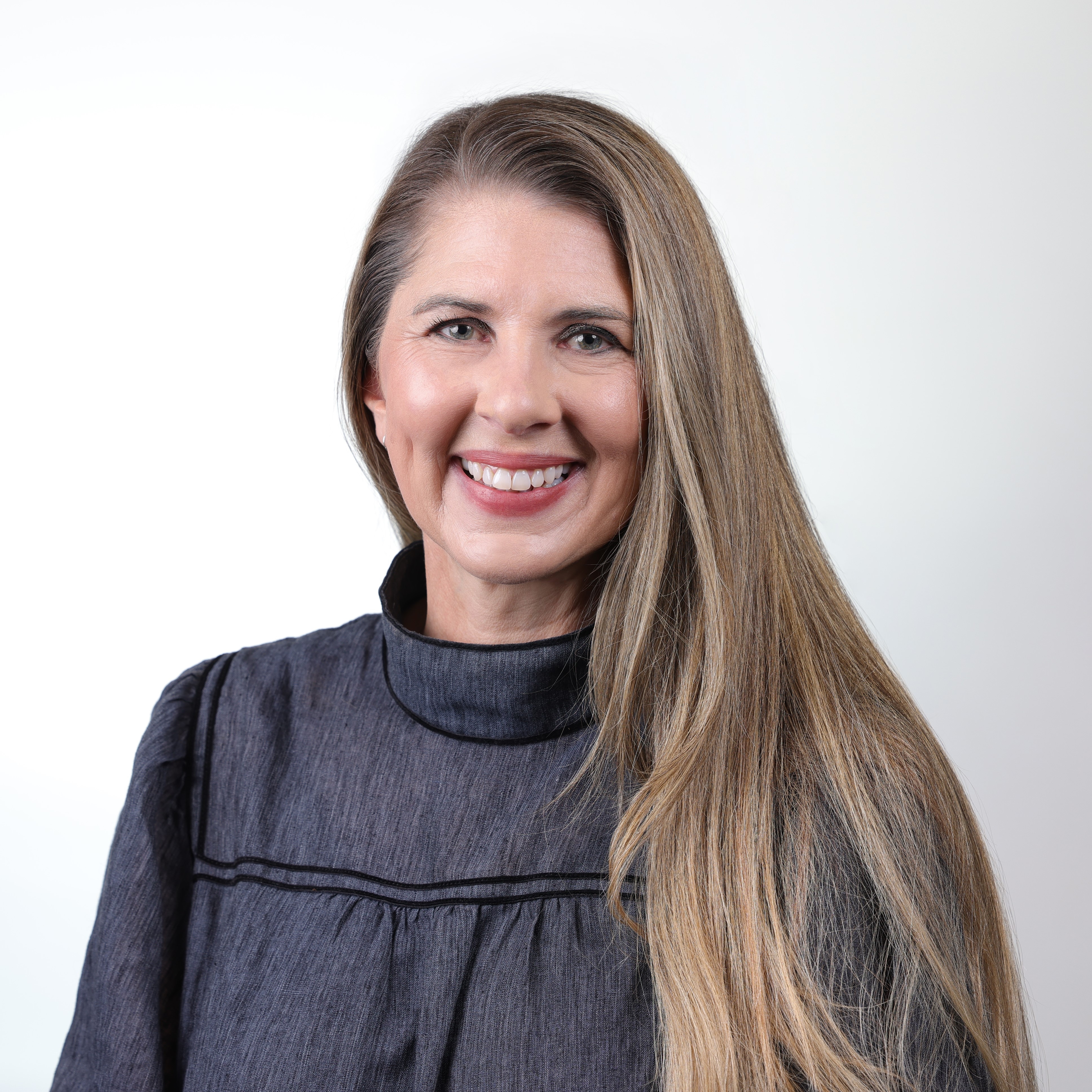 Jayde Richmond headshot, with brown hair, and a black shirt, smiling.
