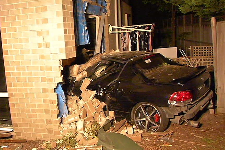 A car is seen crashed into a house.