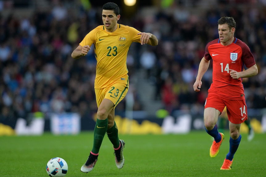 Tom Rogic de Socceroos corre con el balón lejos de James Milner de Inglaterra durante un amistoso internacional.