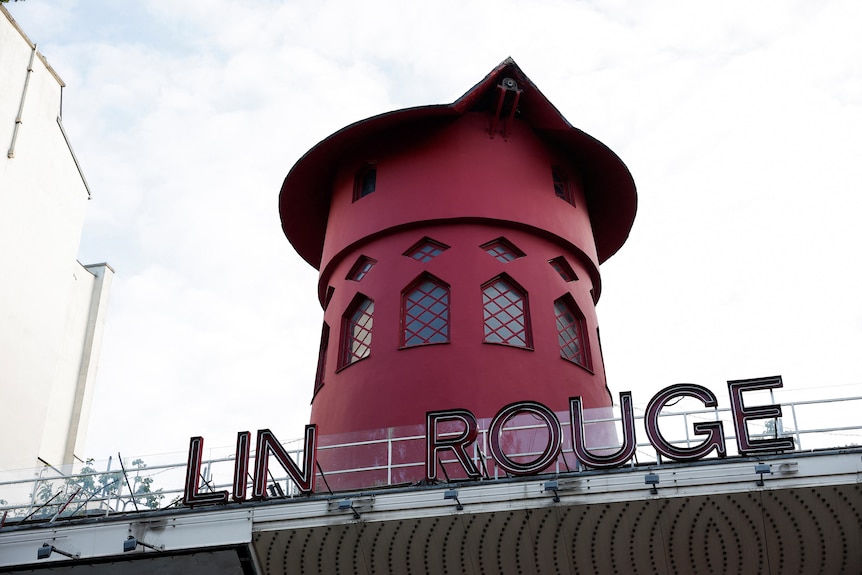 The Moulin Rouge sign missing some letters with the windmill sails missing.