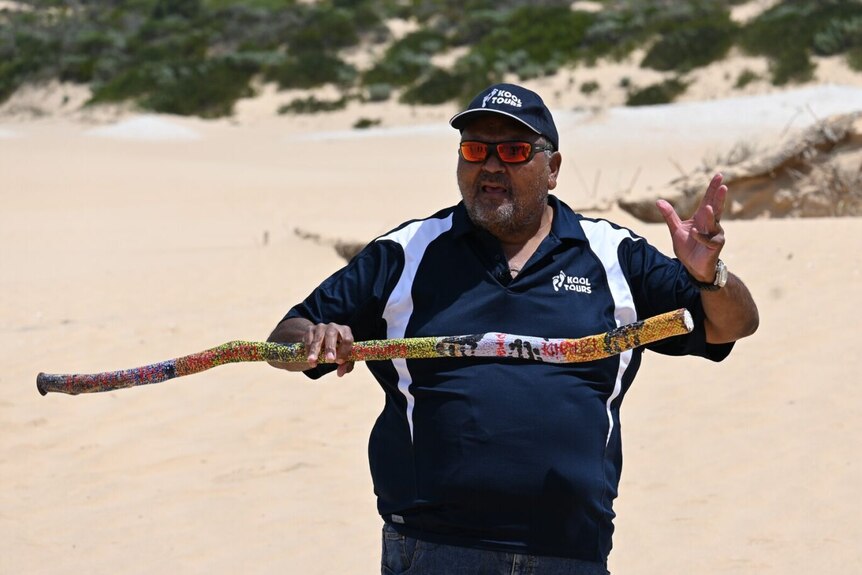 An Aboriginal man holding a stick.