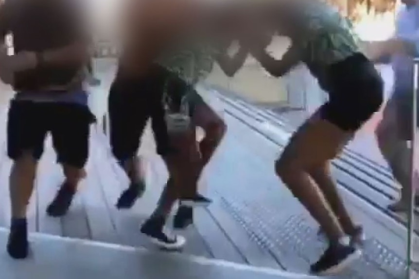 Blurred faces on an image of students fighting at a school