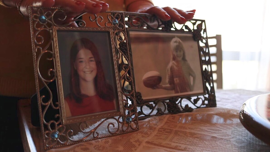 Sylvia's hands touching photos of her daughter Clare, before she died.