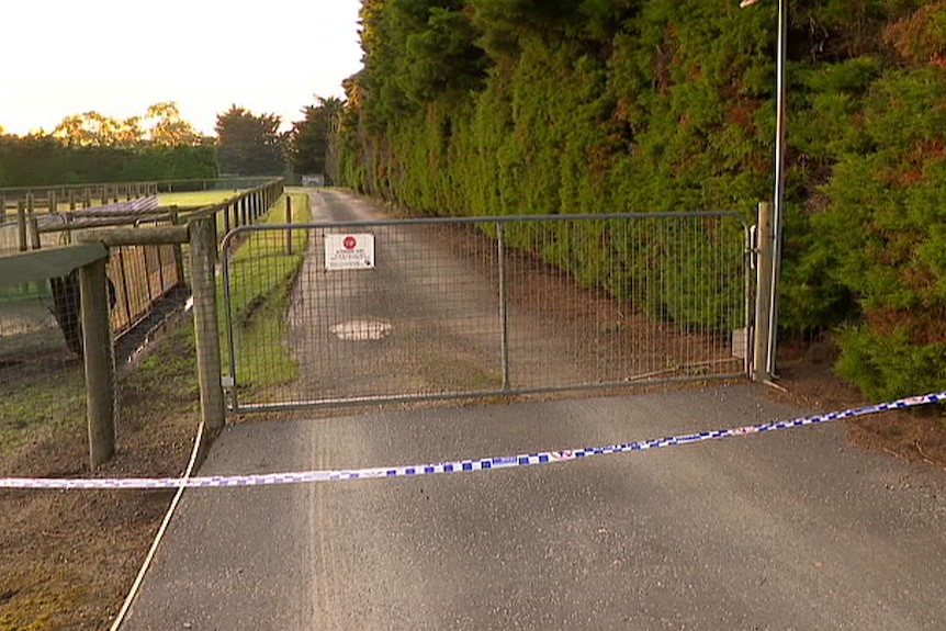 Police tape across the driveway of a property.