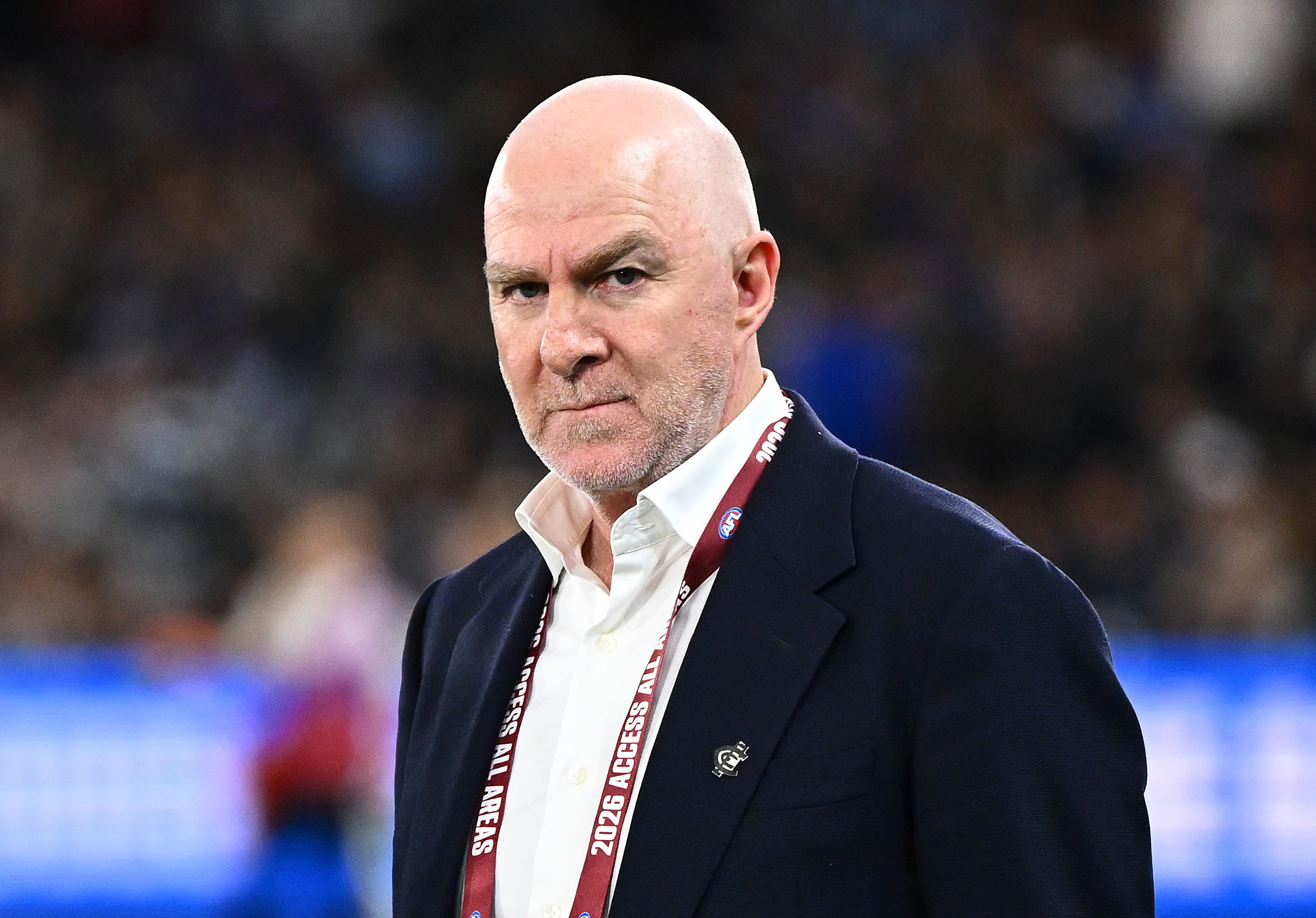 Graham Wright stands on the field wearing a suit