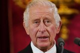 King Charles III speaks in front of a microphone