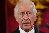 King Charles III speaks in front of a microphone
