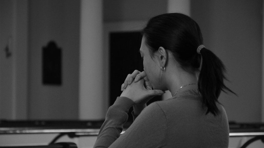 A woman prays in a church