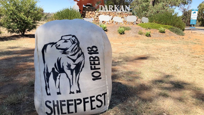 A bale of wool used as a sign in front of a town sign for Darkan.