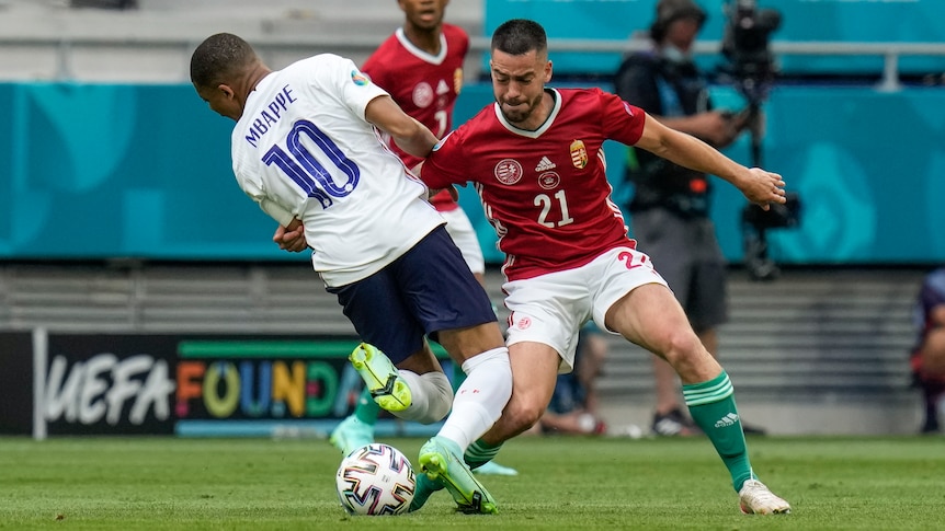 Two players tussle for a ball.