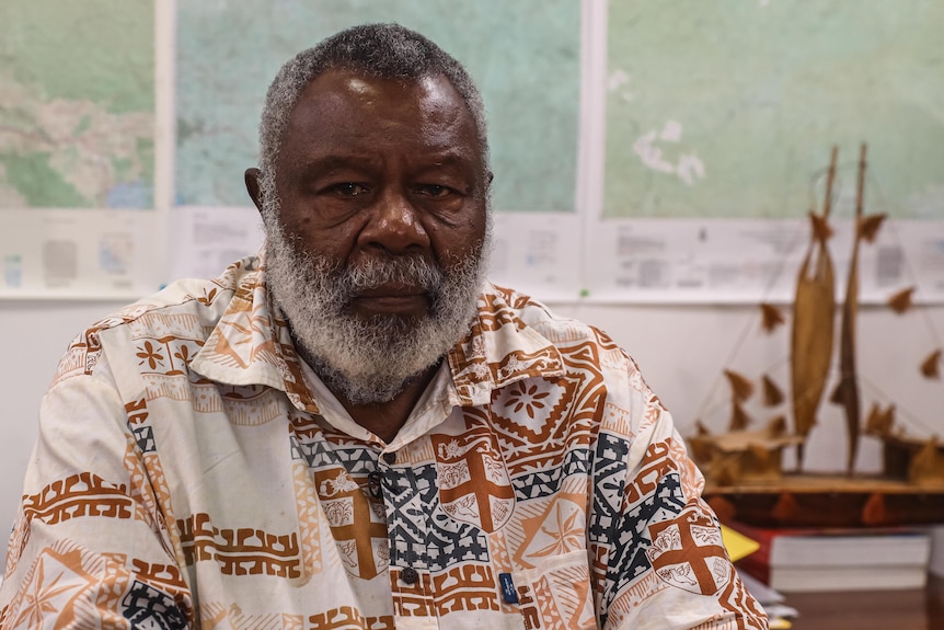 A portrait photo of a man in an office.