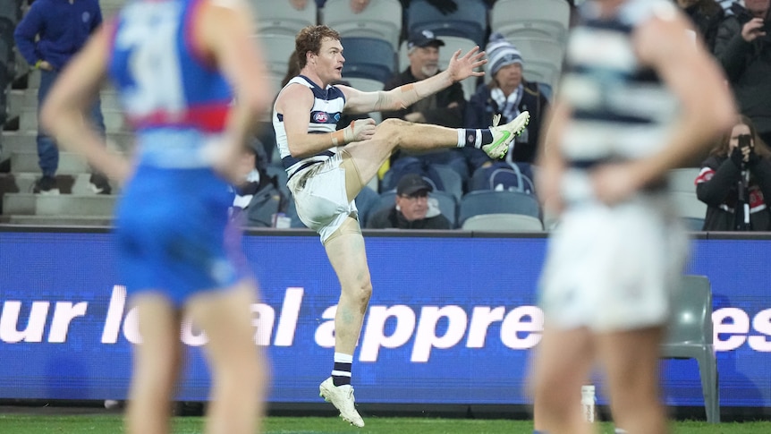 Geelong's Gary Rohan extends his leg mid-kick and watches on.