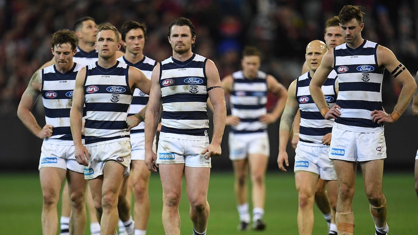 The Cats walk off the MCG looking disappointed after losing to the Demons.