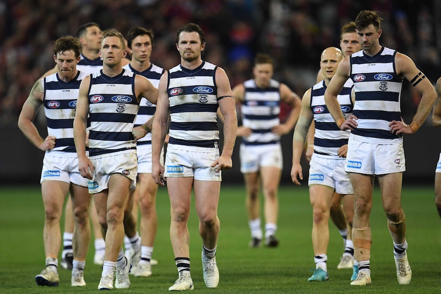 The Cats walk off the MCG looking disappointed after losing to the Demons.