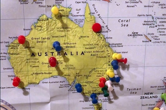 A map of Australia with many thumb tacks placed in it.