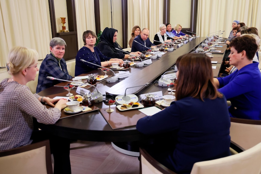 Vladimir Putin se întâlnește cu mamele militarilor la o masă lungă.