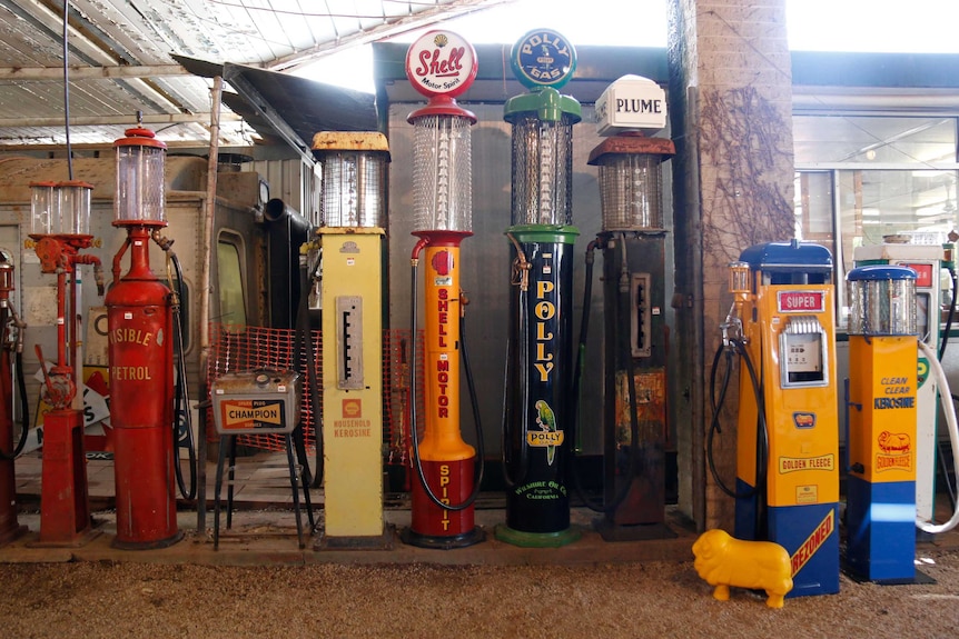 A row of colourful, old fashioned petrol pumps.