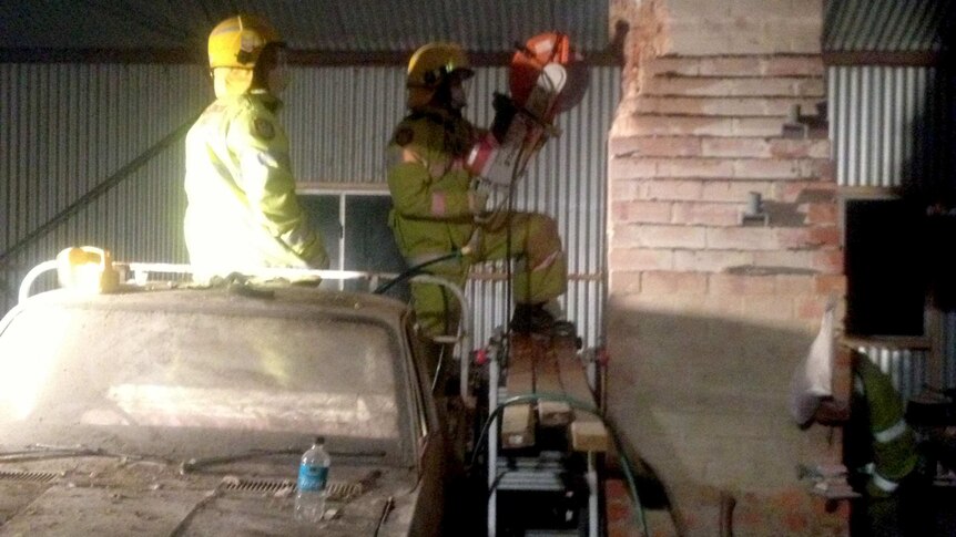 A power tool is used to cut bricks from a chimney where a teen was trapped