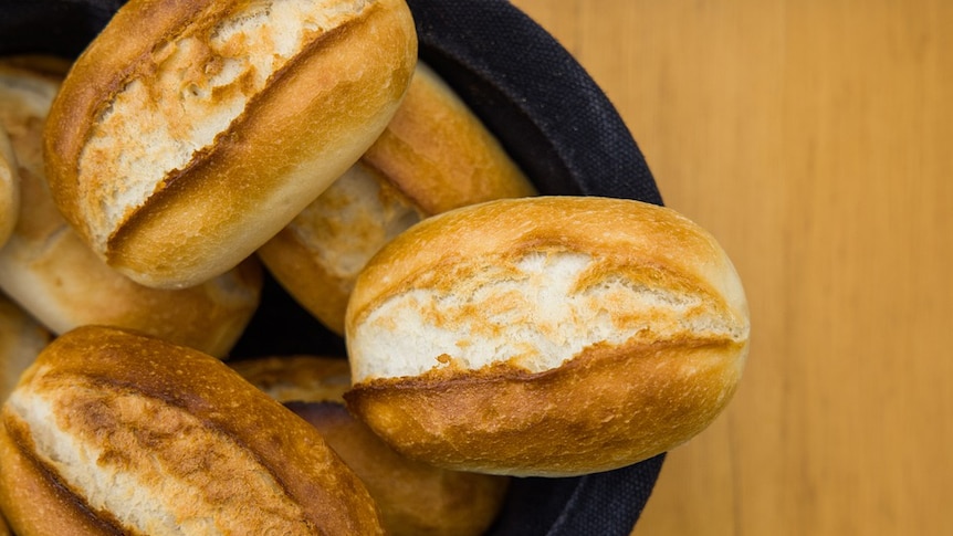 Bowl of bread rolls with a white background