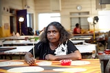 A woman does dot painting in an indigenous arts centre