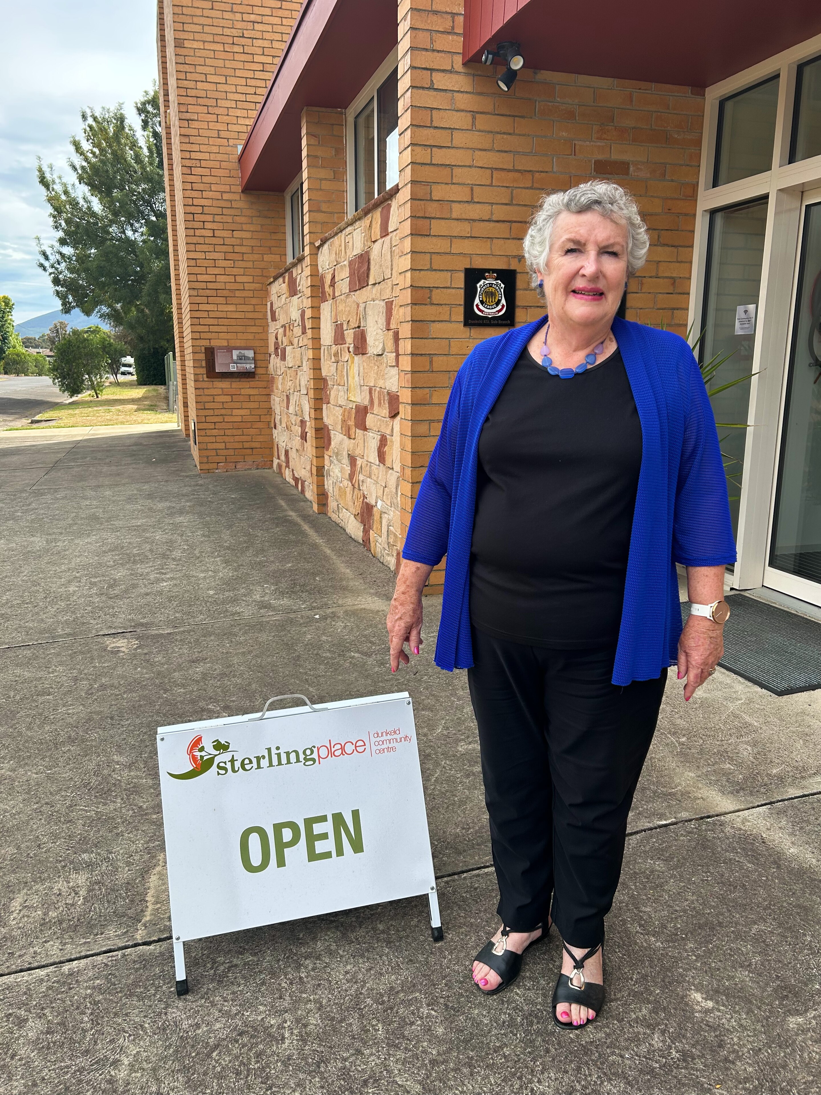 A woman stands in front of a council building.
