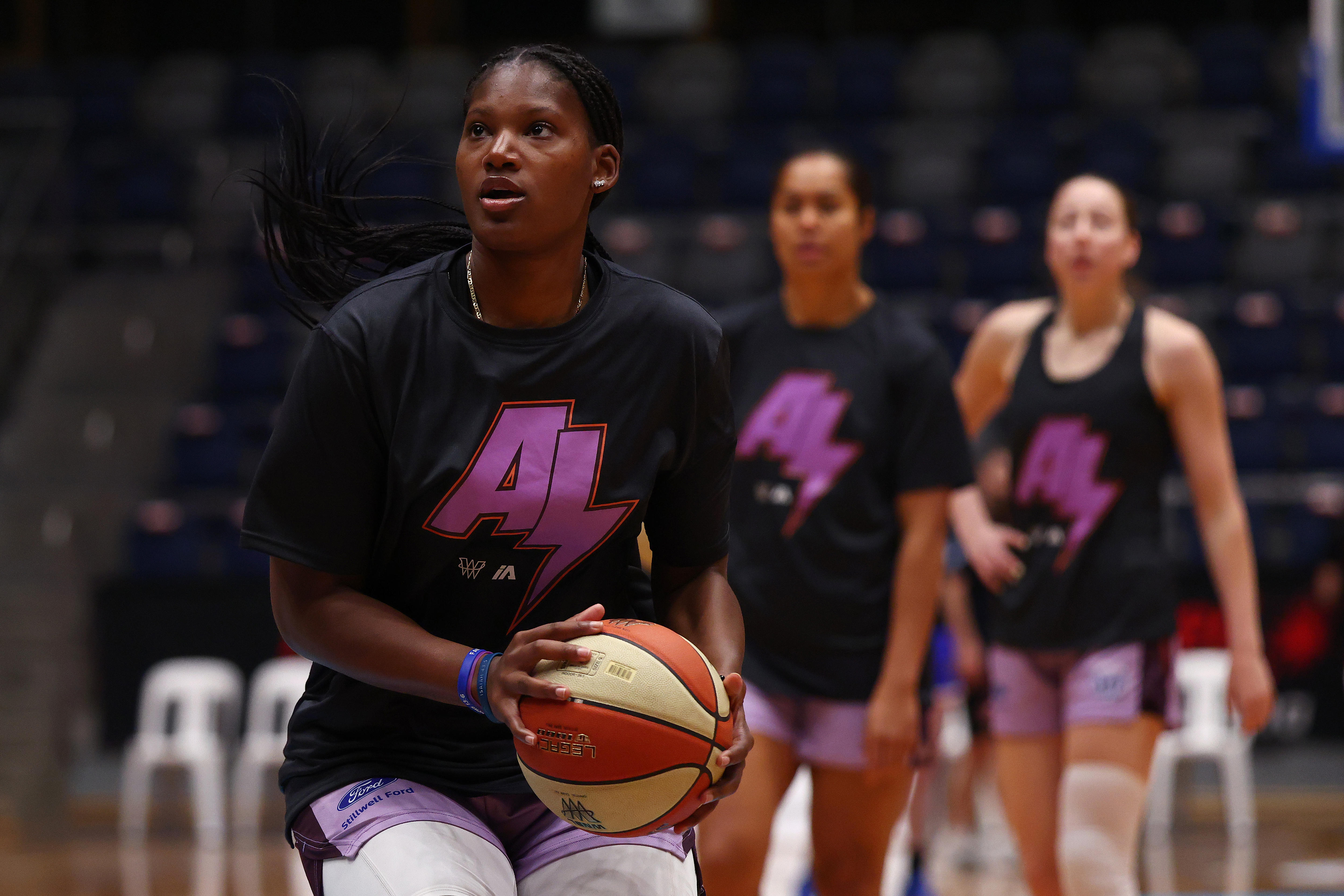 Una mujer sostiene una pelota de baloncesto en sus manos.