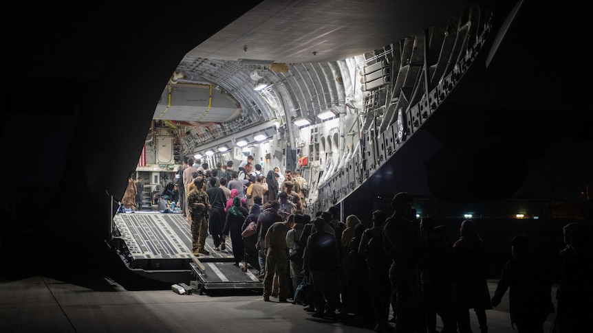 People file into the hold of a US plane.