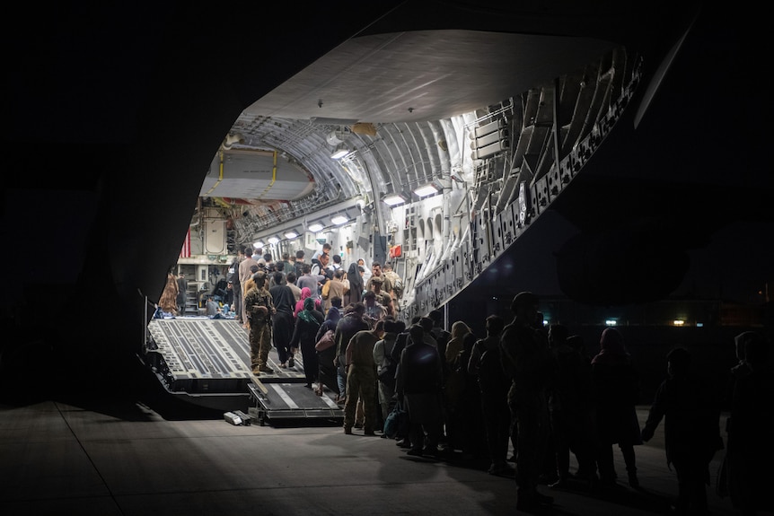 People file into the hold of a US plane.