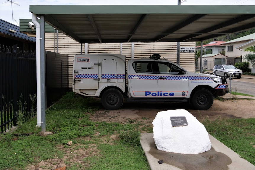 the white memorial rock in front of the police station and police car